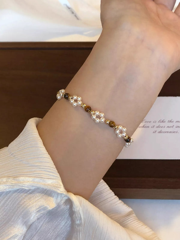 Tiger eye beads and white pearls worn around the wrist