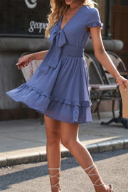Blue dress shown in motion with flared ruffle hem