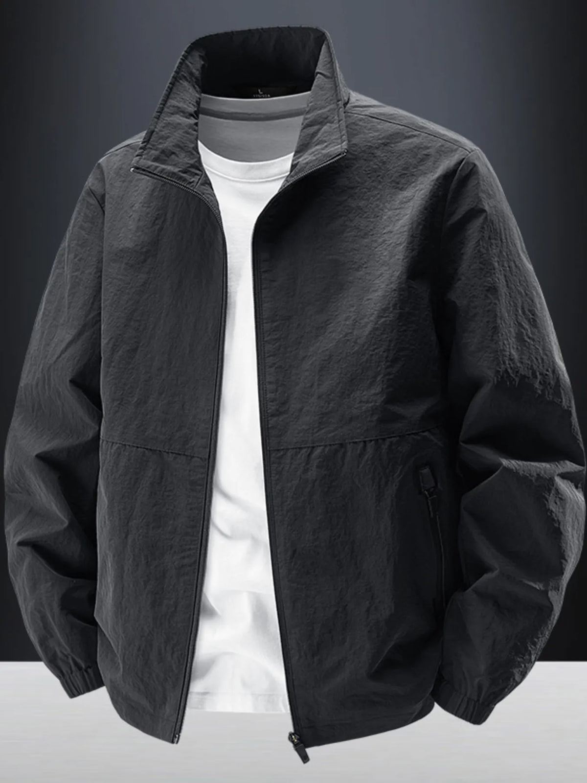 Black zip-front jacket displayed over a white T-shirt against a dark background