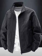 Black zip-front jacket displayed over a white T-shirt against a dark background