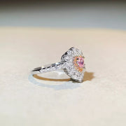 Side profile of the heart-shaped pink center stone and clear-stone halo.