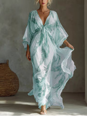 White and mint feather-print maxi dress with a tied V-neckline and loose sleeves, front view.