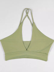 Light green halter crop cami displayed flat with crossed halter straps and front cutout