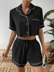 Front view of black cropped pajama shirt and matching shorts with white piping