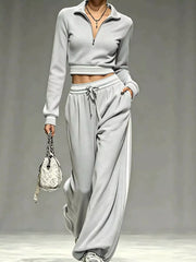 Model in navy half-zip crop top and pants set, close front view