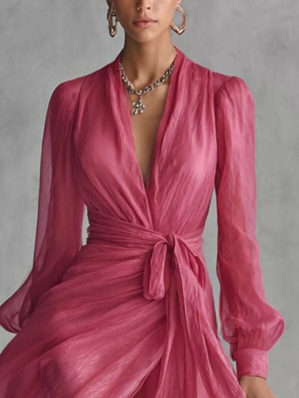 Close view of the pink wrap dress showing the deep V-neckline, sheer sleeves and waist bow.