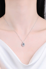 Oval pendant necklace worn above a white neckline