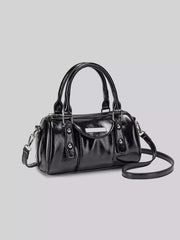 Front three-quarter view of the glossy black Boston bag with the detachable strap extended.
