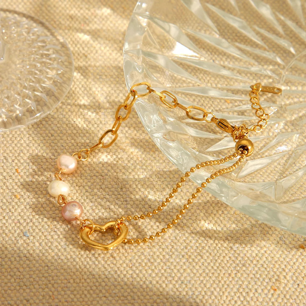Gold-tone heart pearl bracelet arranged in a loop