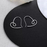 Pair of heart-shaped silver wire earrings viewed from above