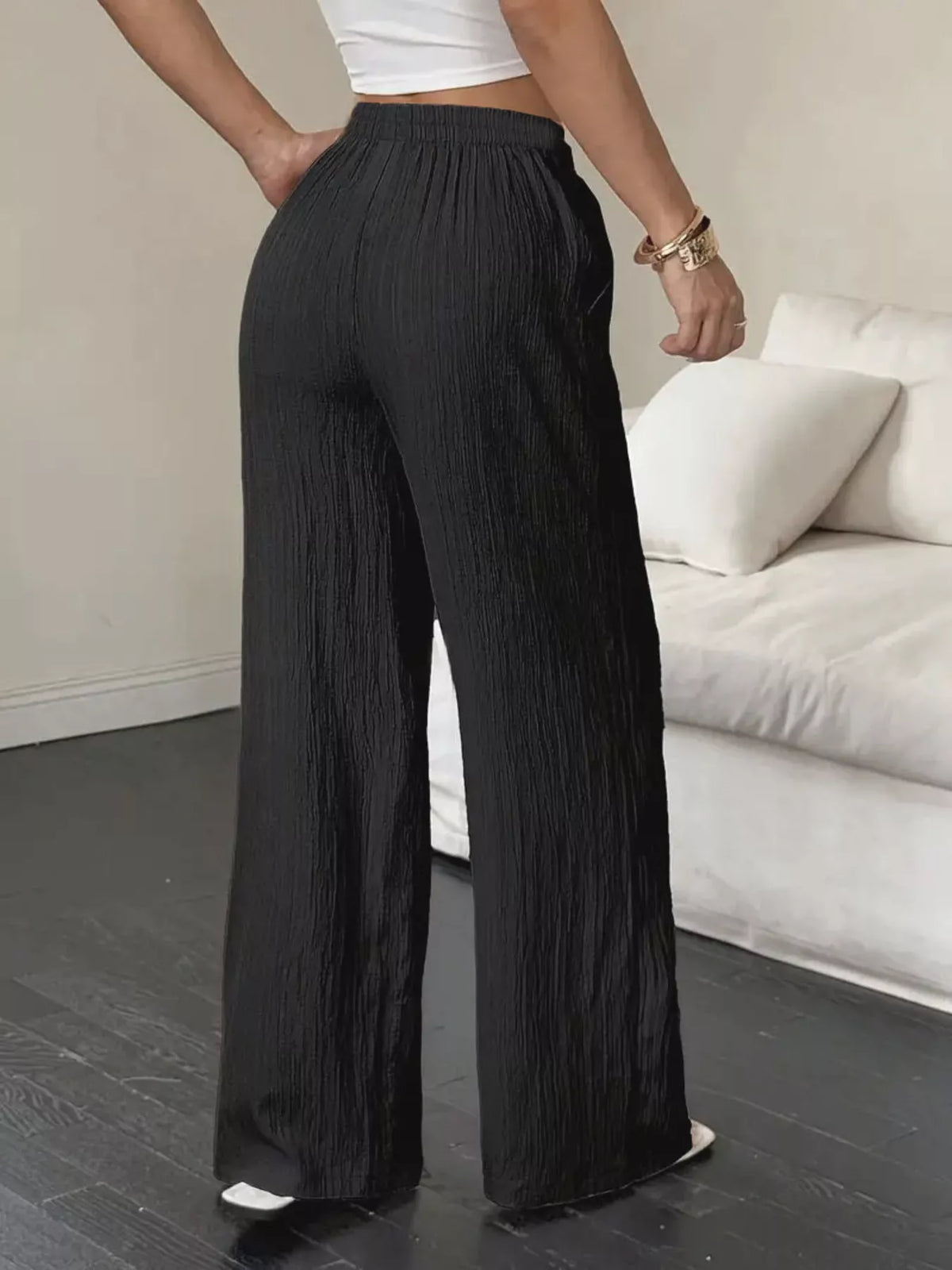 Back view of black wide-leg drawstring pants with flowing full-length legs