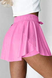 Back view of pink skort with layered side flounces and elastic waistband.