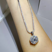 Round moissanite pendant necklace shown draped over a model's arm