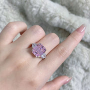 Blush pink rectangular zircon ring worn on a hand, with clear triangular side stones