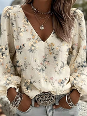 Close view of cream floral print blouse with V neckline and gathered shoulders