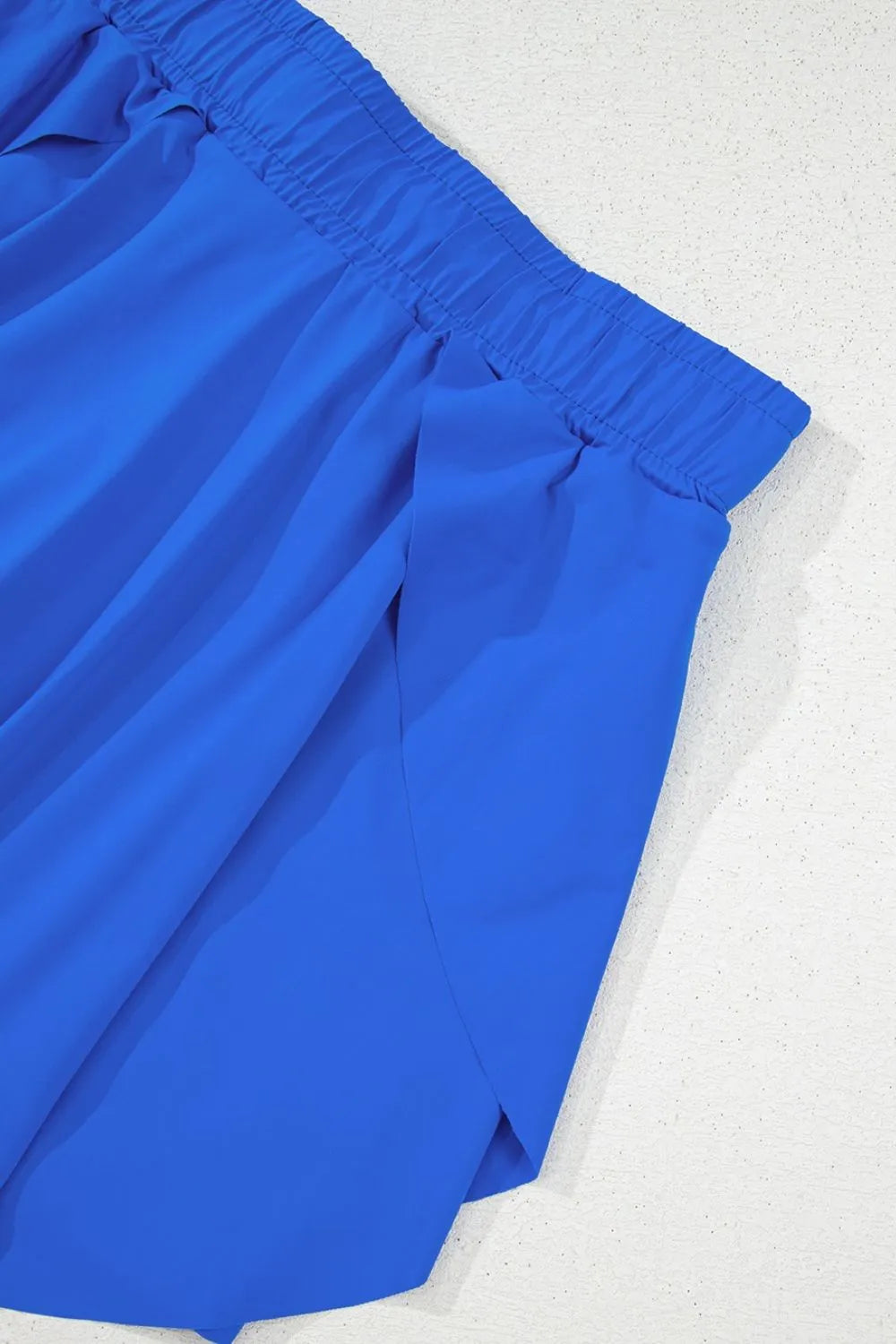 Close-up of blue skort's overlapping skirt panels and side seam