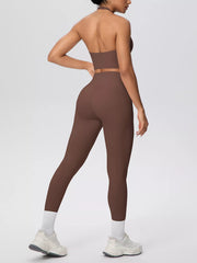 Brown activewear set shown from behind with hand on hip