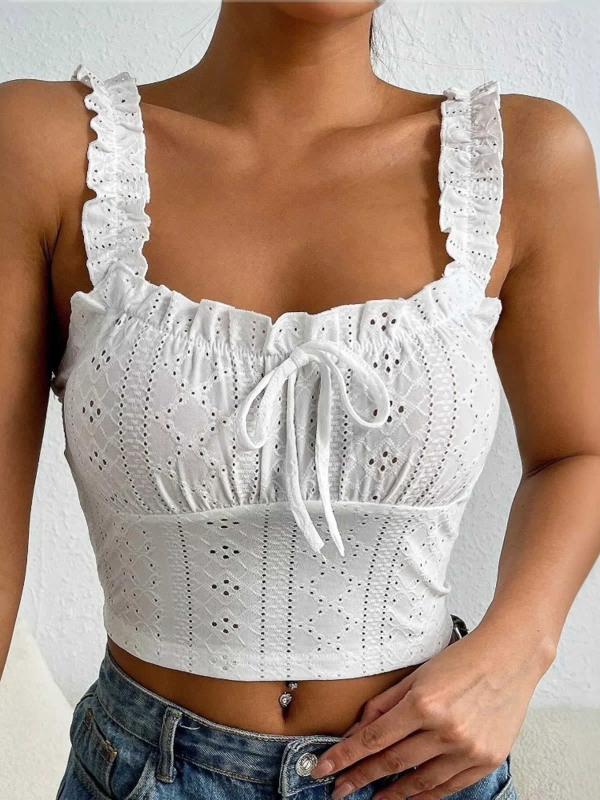 Close-up of white eyelet tank bodice with ruffled straps and tie