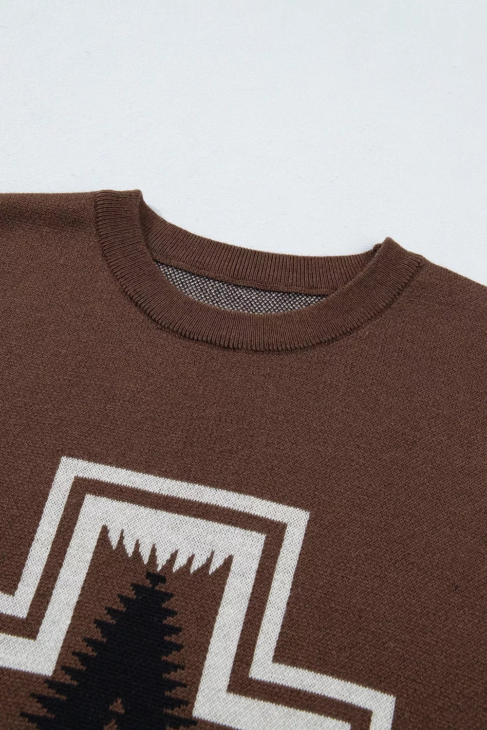 Close-up of brown tee crew neckline and western cross chest graphic