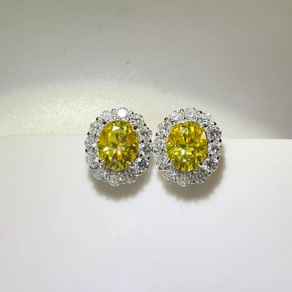 Front view of yellow oval stud earrings with clear stone halos.