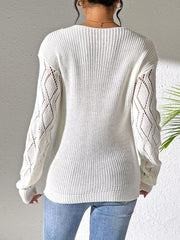 Back view of the white sweater showing its plain knit body and openwork sleeves.