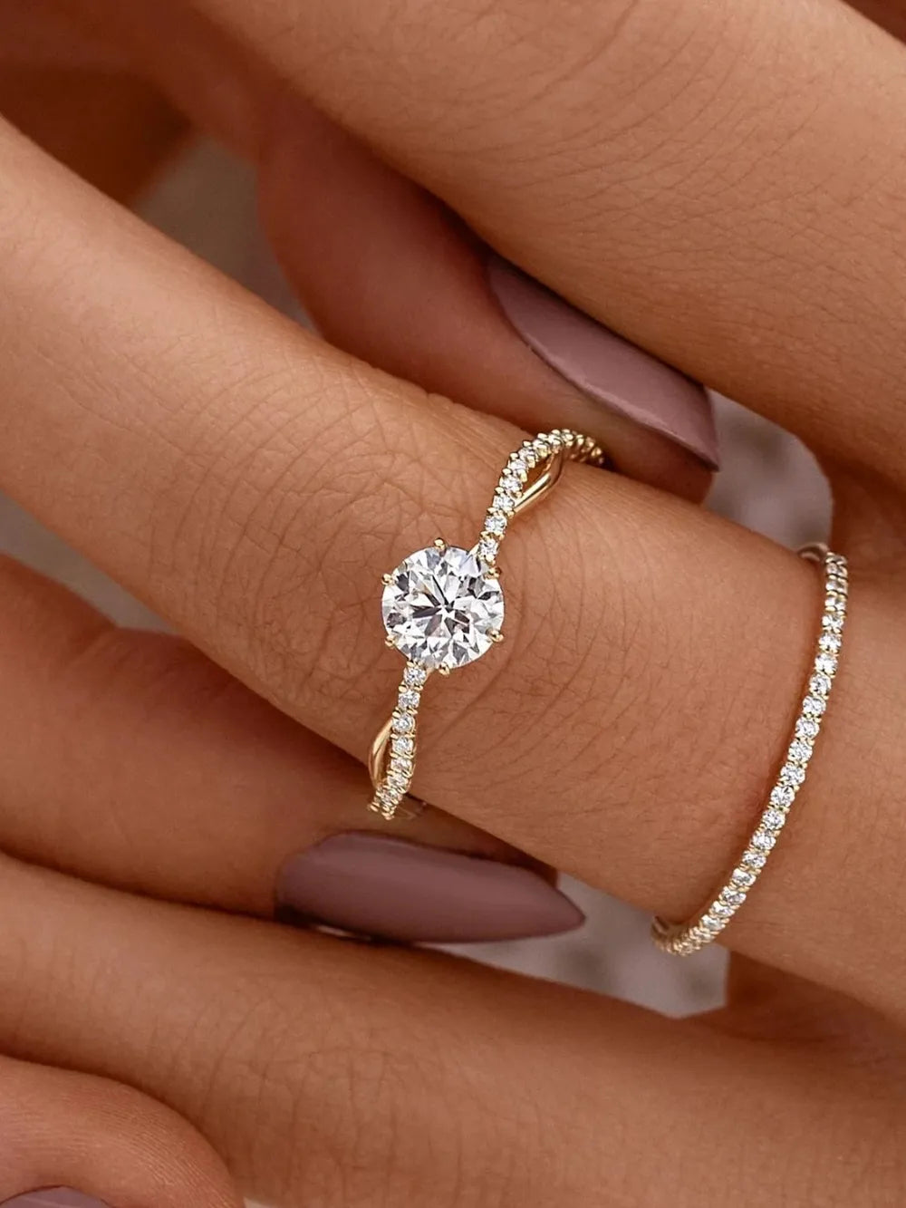 Gold-tone sterling silver ring with a prominent clear zircon on white