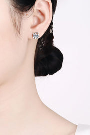 Silver-tone curled-surround stud earring worn on an ear