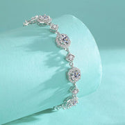 Side view of the silver-tone bracelet draped over turquoise fabric