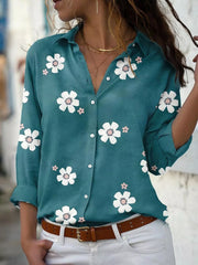 Teal floral button-down shirt with rolled sleeves, front view.