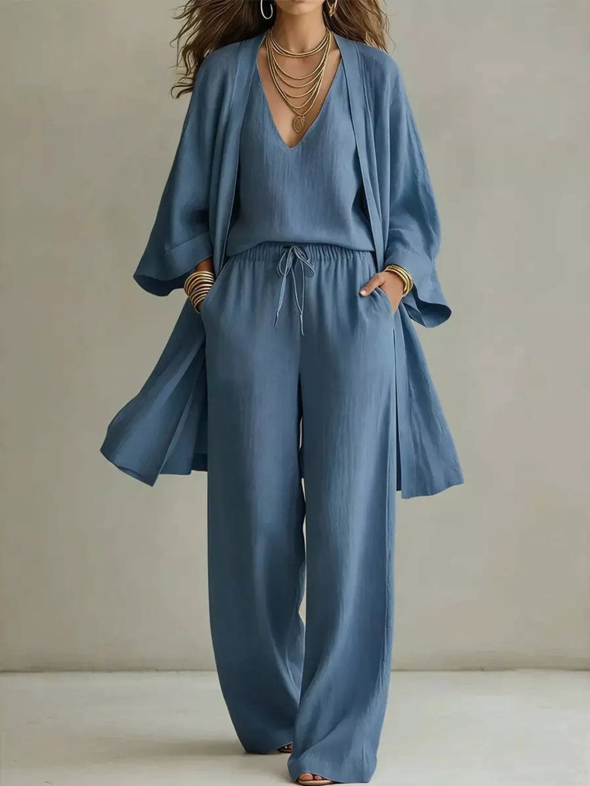 Woman in a blue V-neck cardigan and matching pants, full-length view.