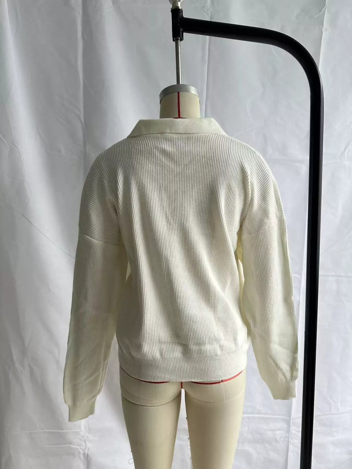 Cream ribbed polo sweater displayed on mannequin, back view