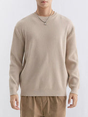 Front view of beige ribbed sweater showing rounded neckline and cuffed long sleeves