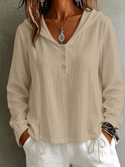 Women's white hooded long-sleeve blouse with button details and drawstring, close-up
