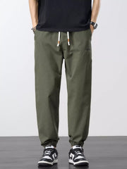 Front view of olive joggers with drawstring waist, pockets and elastic cuffs.