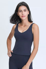 Front view of a woman wearing a navy V-neck active tank top.