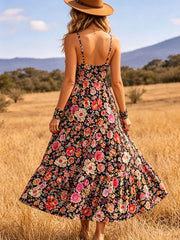 Back view of black floral midi dress showing thin straps and flared skirt