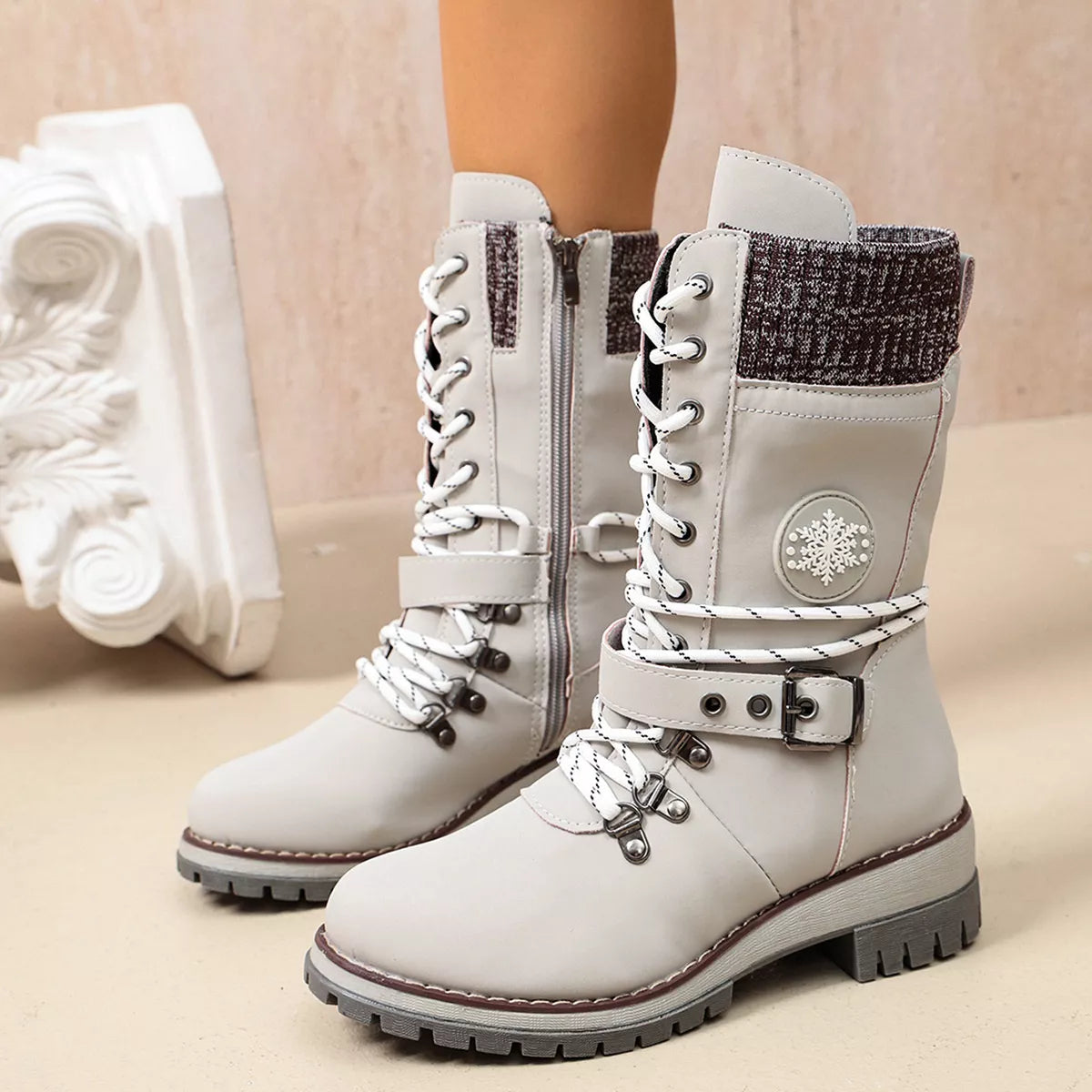 White lace-up ankle boots with buckle straps and knit cuffs