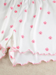 Detail of white ribbed floral-print shorts with pink scalloped edge