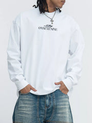 Model in a white long-sleeve tee with small dark lettering across the chest