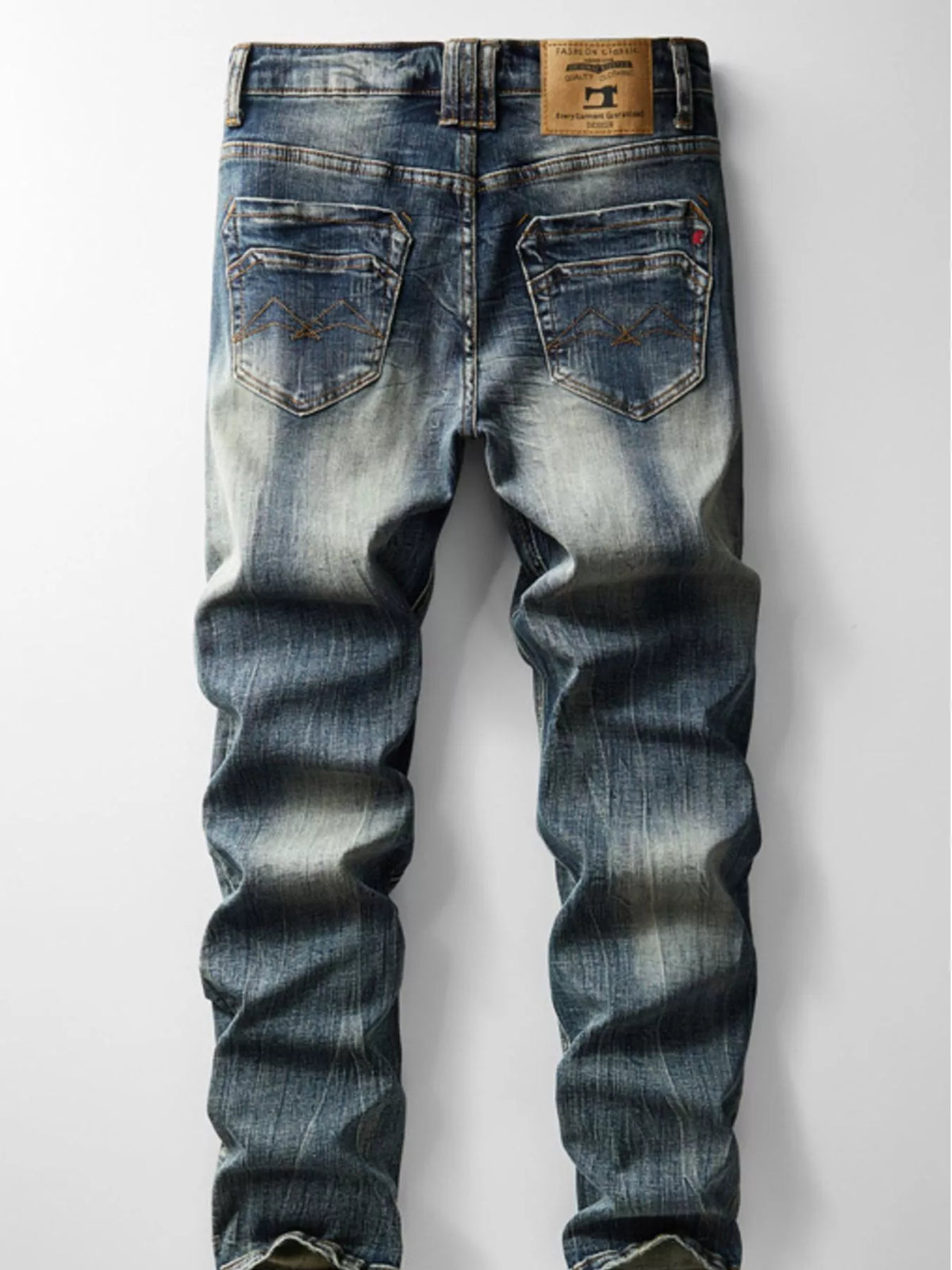 Back view of men's blue vintage-wash jeans showing stitched pockets and a waistband patch