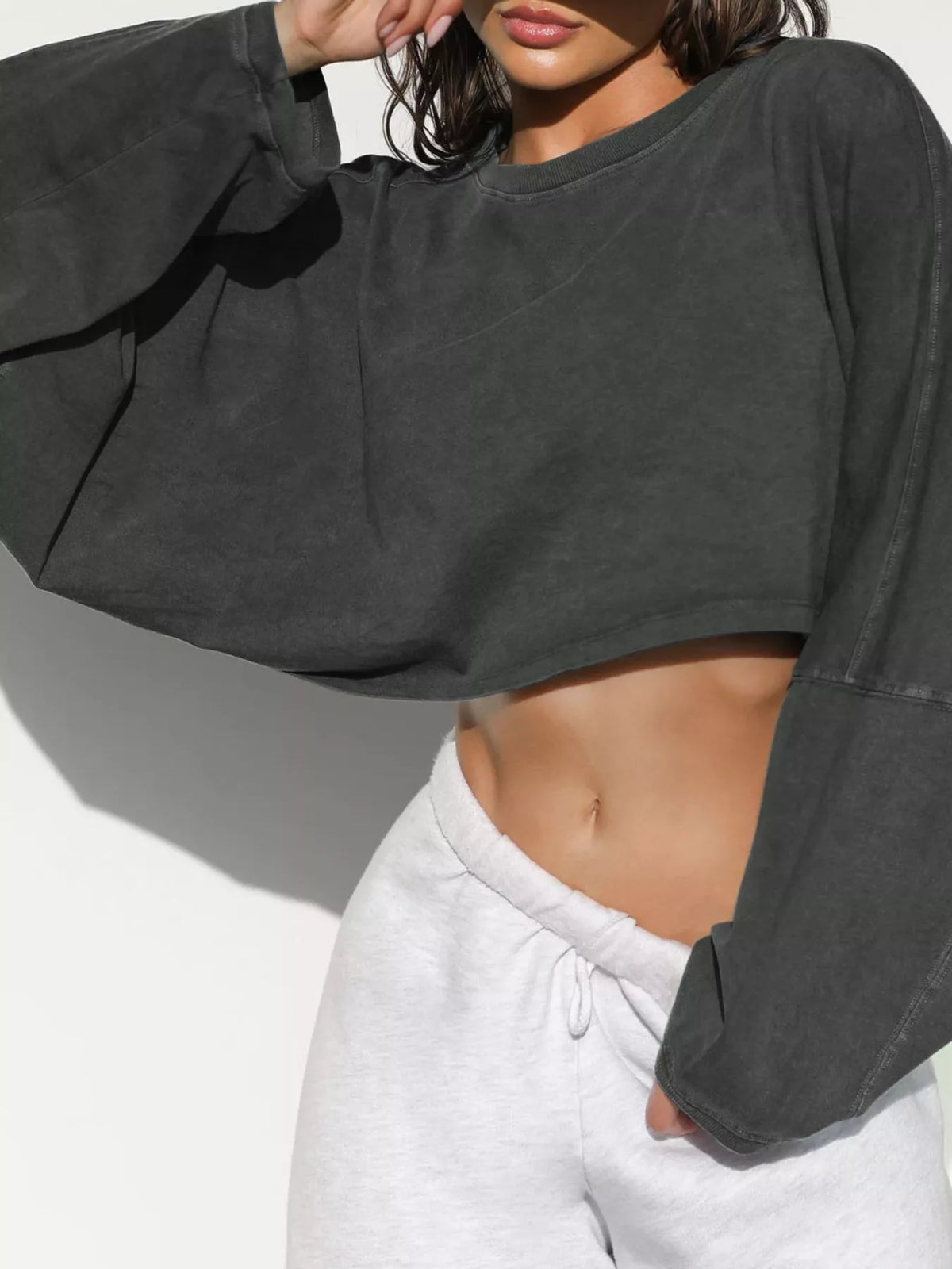 Close view of charcoal cropped sweatshirt neckline and oversized sleeve