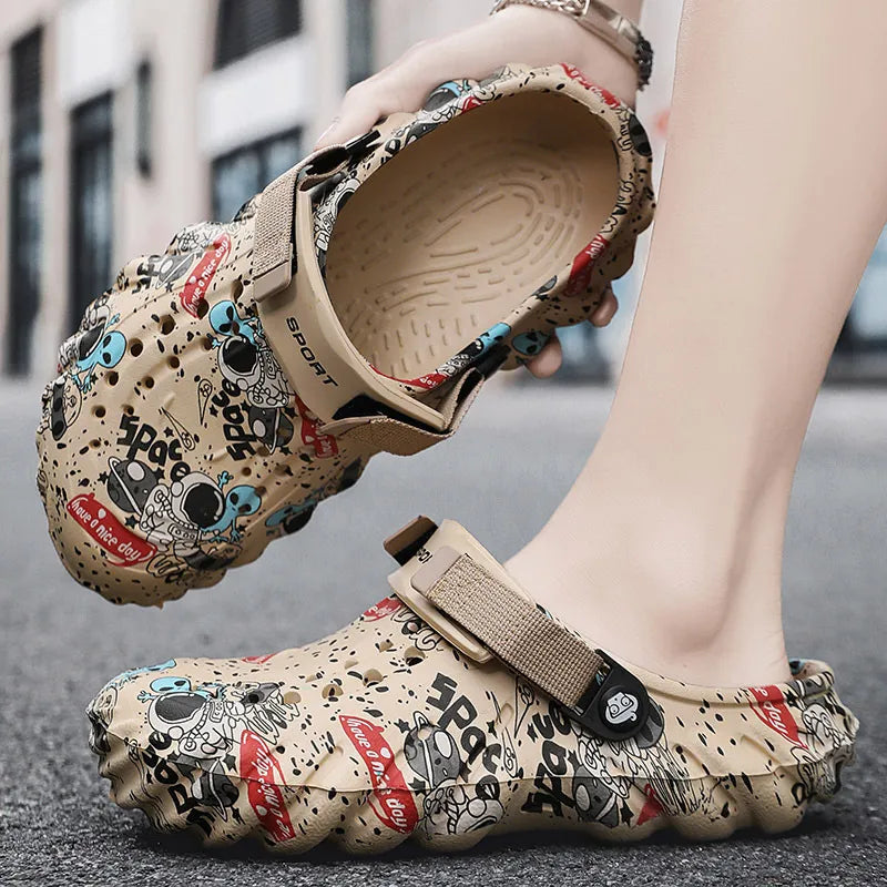 Beige graffiti-print clog held to show its textured footbed beside a matching shoe on a foot