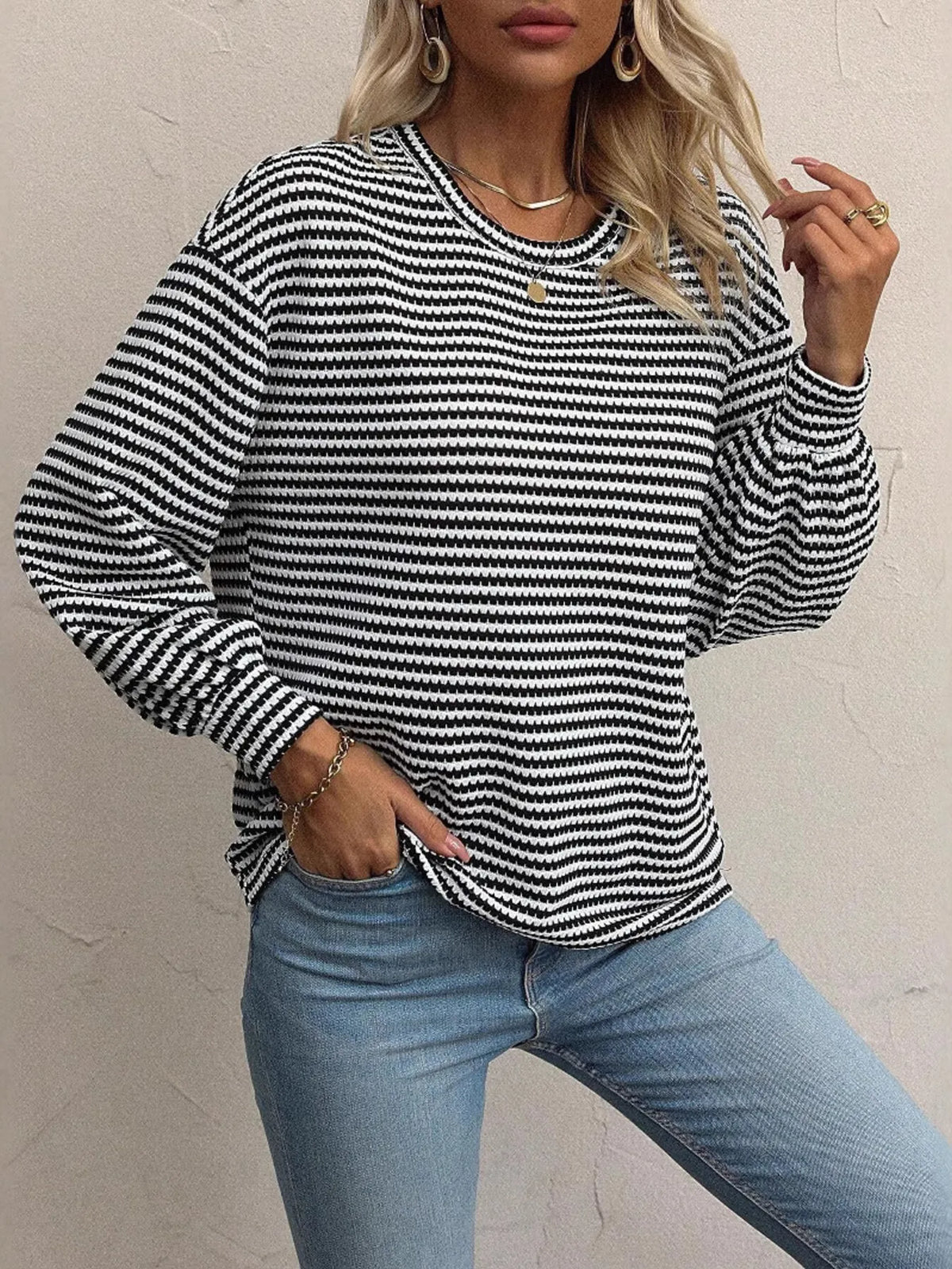 Front view of striped lantern-sleeve top styled with jeans