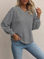Front view of striped lantern-sleeve top styled with jeans