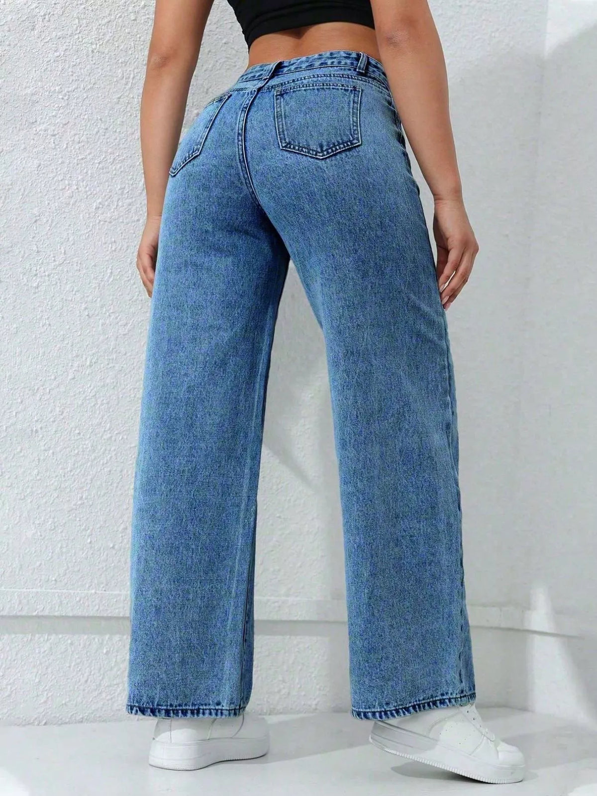 Rear view of blue wide-leg jeans showing two back patch pockets