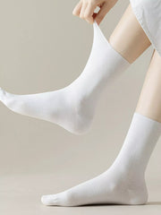 Close-up of a white mid-calf sock being stretched to show its shape
