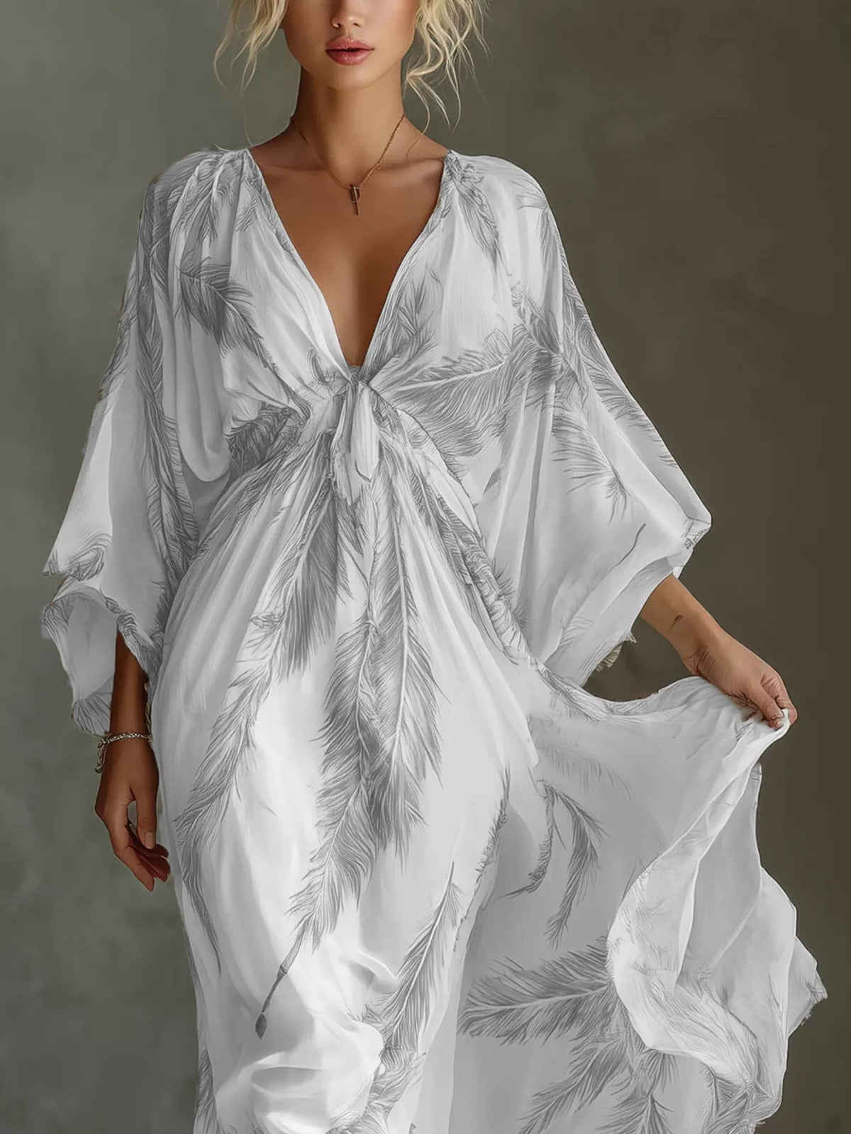 Close view of the grey feather-print maxi dress showing its tied V-neckline and gathered front.