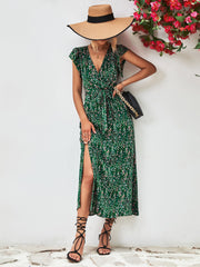 Green printed V-neck dress with a side slit, shown on a model carrying a shoulder bag.