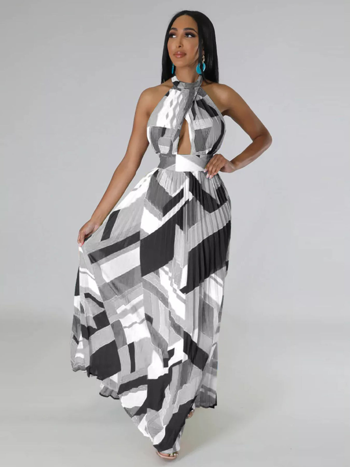 Black-and-white geometric maxi dress on a model with one hand on her hip and the skirt spread outward.