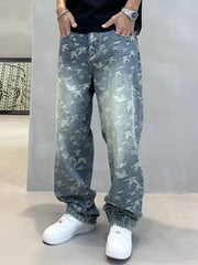 Angled front view of faded blue bird-print jeans with loose legs